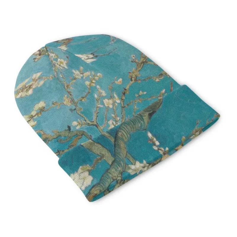 Side angle of the Almond Blossom beanie showing dark branches and white blossoms wrapping around the crown and cuff.