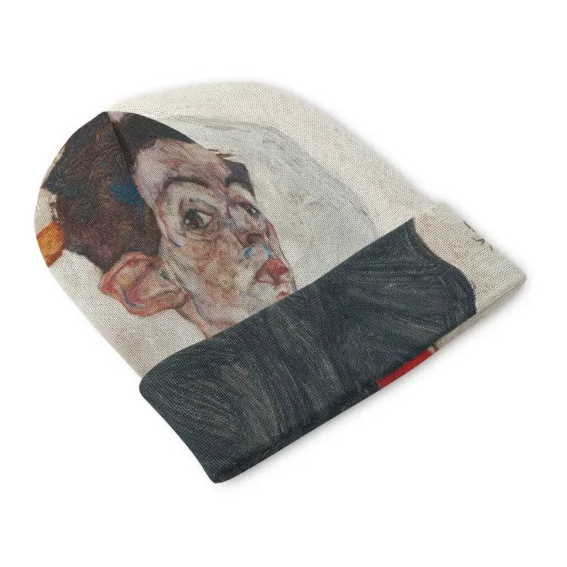 Front view of the Self-Portrait with Physalis beanie with hanging physalis forms, pale ground and a bold red fruit panel contrasted against the black cuff.