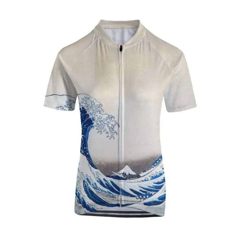 Woman cyclist wearing The Great Wave off Kanagawa jersey ascending coastal road with ocean view